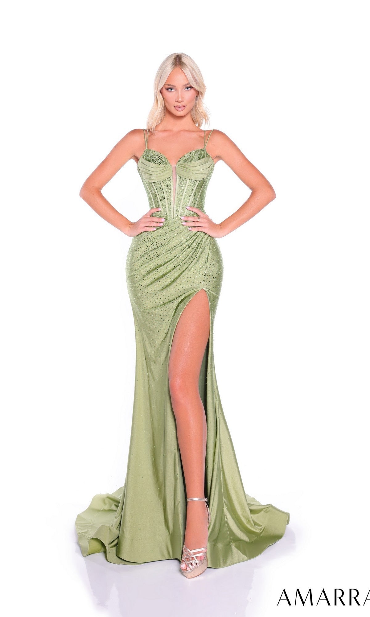 A woman poses in the Lace-Up Long Corset Prom Dress: Amarra 89325, a light green fitted gown with a high slit, thin straps, and strappy open back. She pairs it with strappy heels and stands against a white background.